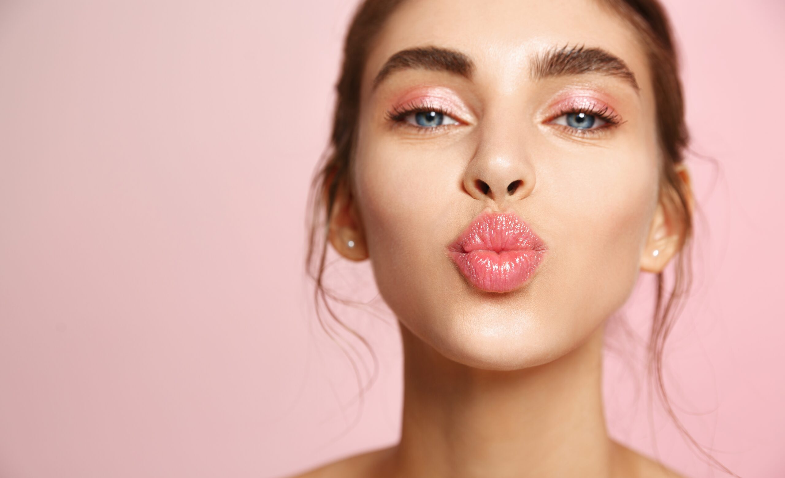 beautiful young woman pursing her lips after lip augmentation