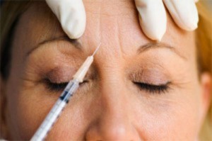 middle-age woman receiving a Botox injection for frown lines