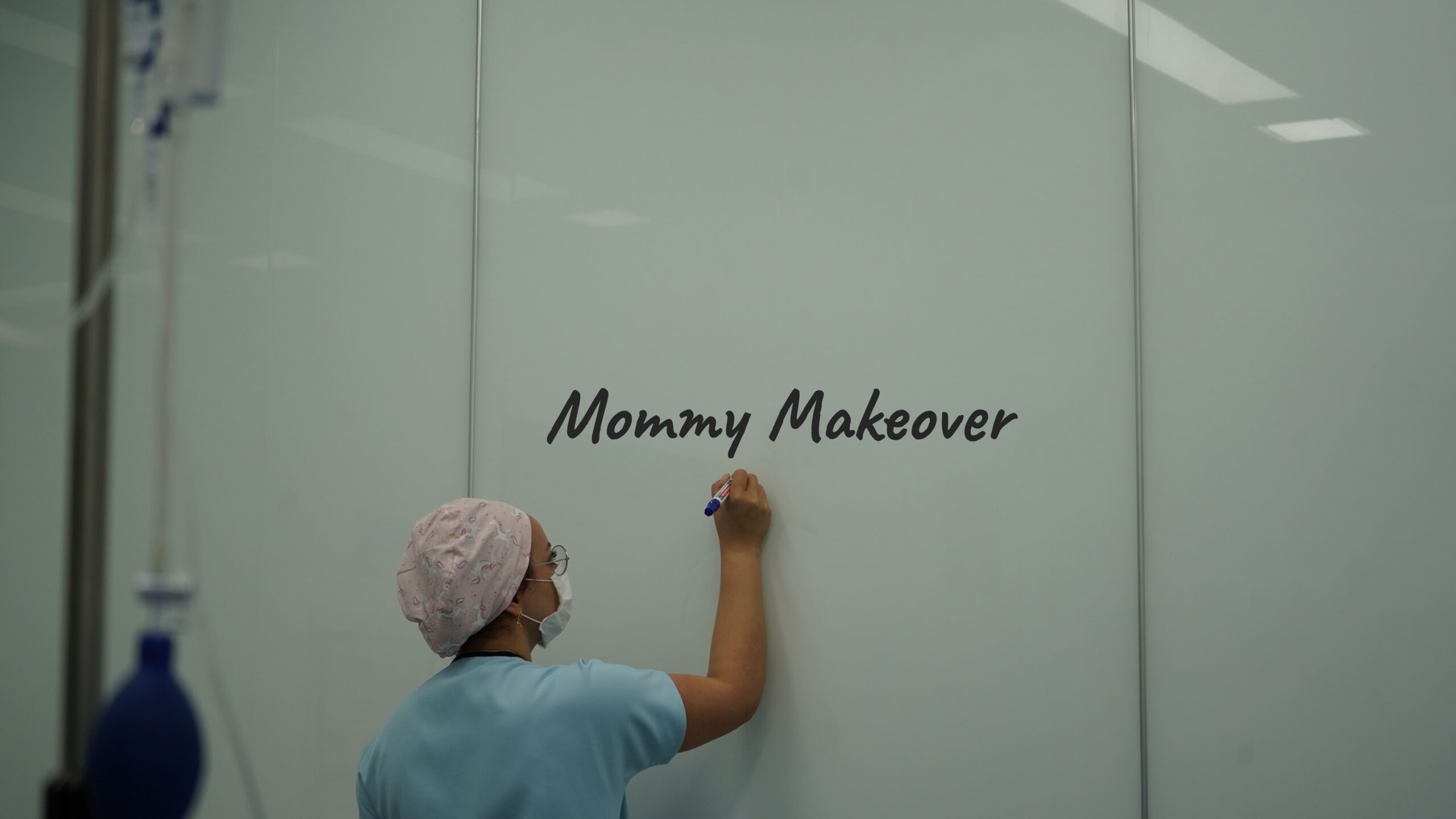 surgeon writing on a board mommy makeover