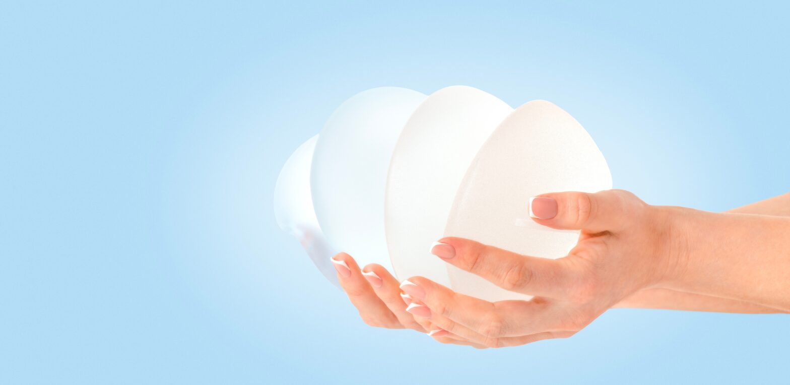 hands holding breast implants