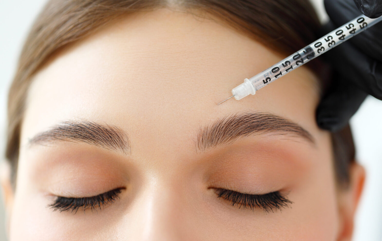 Injectable treatment performed on women's forehead