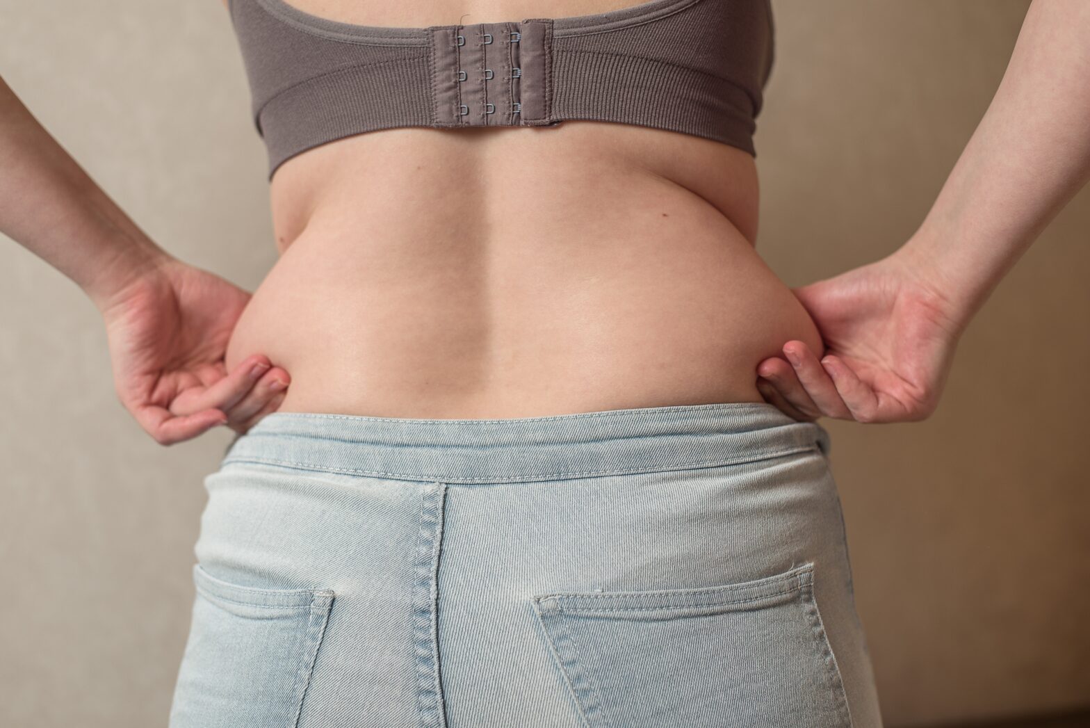 woman squeezing love handles